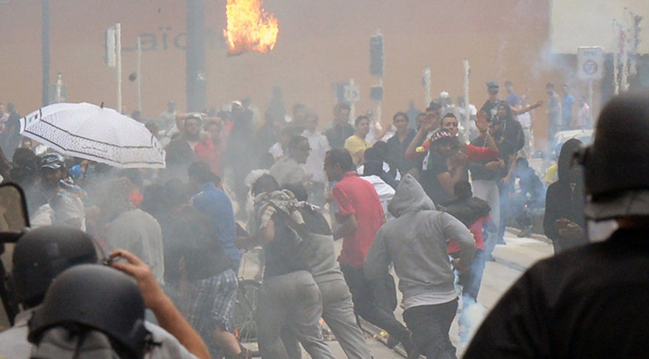 *Police officers chase rioters in the Paris suburb of Sarcelles on July 20. Several Jewish-owned stores were burned.* Pierre Andrieu/AFP/Getty Images. Sarcelles-Cover