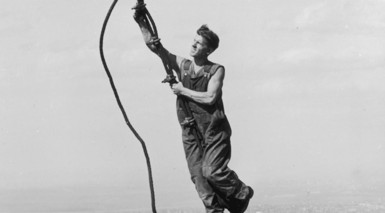 *A construction worker connects two cables suspended high above the New York during the construction of the Empire State Building, 1931.* Photo credit: Lewis W. Hine/George Eastman House/Getty Images. empirestateclimber65