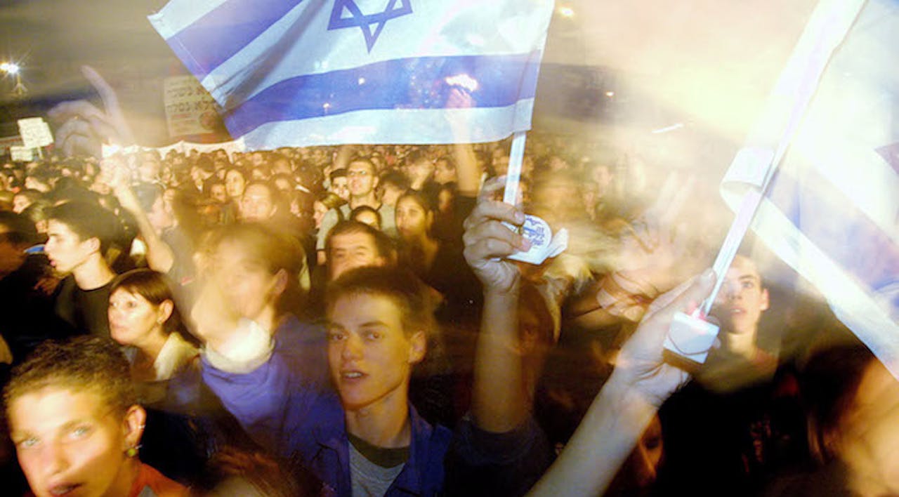 *Demonstrators sing peace songs during a rally in Tel Aviv in 2002.* Quique Kierszenbaum/Getty Images. march