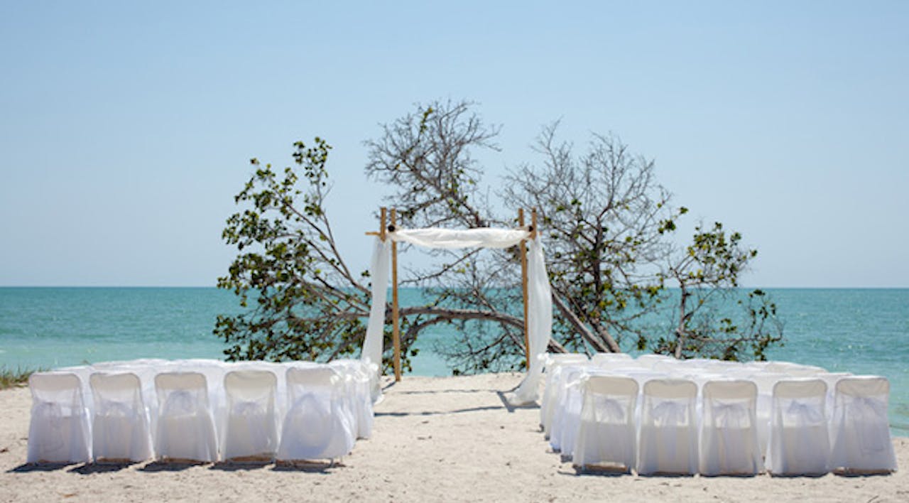 *Wedding on the beach, chairs and huppah.* © Matthew Valentine | Dreamstime.com. chuppa33