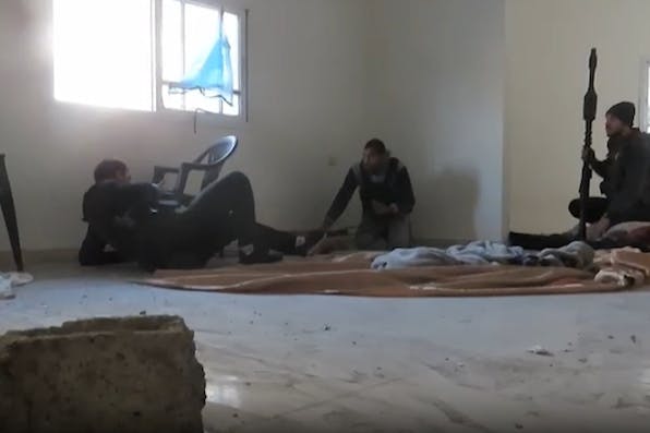 Hamas fighters prepare to launch an RPG from a civilian residence. *IDF*. terrorists-banner