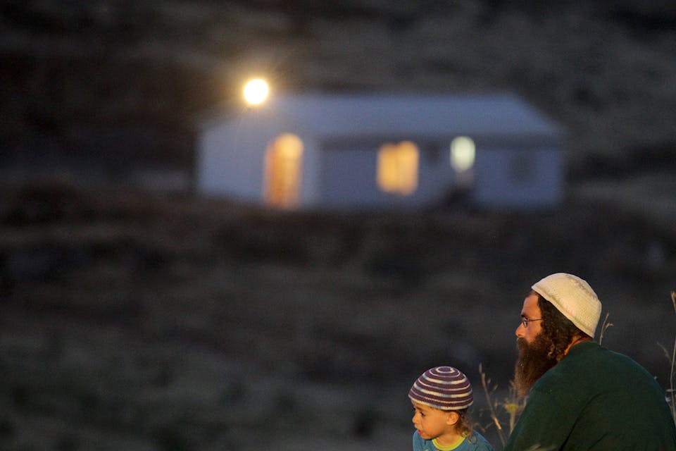 A religious father and his son sit near the Havat Gilad settlement on May 28, 2012. *Nati Shohat/Flash90*. Kane LW