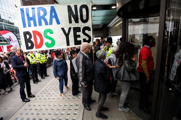 On September 4, 2018, in London, protesters demonstrate against the adoption of the IHRA definition of anti-Semitism. *Photo by Jack Taylor/Getty Images.* LONDON, ENGLAND – SEPTEMBER 04: Protesters demonstrate outside a meeting of the National Executive of Britain’s Labour Party on September 4, 2018 in London, England. Labour’s NEC meet today to vote on whether to adopt the full International Holocaust Remembrance Alliance (IHRA) definition of anti-semitism. (Photo by Jack Taylor/Getty Images)