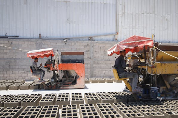 Workers produce bricks from rubble recycled with the aid of an Egyptian delegation in Gaza on Tuesday, June 15, 2021. *Ahmad Salem/Bloomberg via Getty Images.* Gaza Bricks