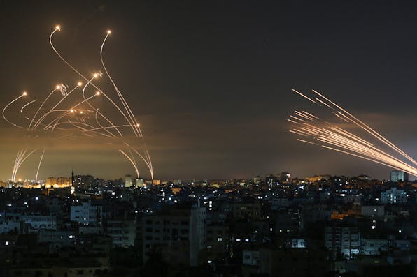 Streaks of light appear as Israel’s Iron Dome anti-missile system intercepts rockets launched from the Gaza Strip on May 16, 2021. *ANAS BABA/AFP via Getty Images.* Main Gaza