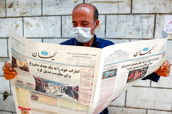 A man in Tehran looking at a Farsi newspaper with a headline declaring “The UAE has become a legitimate and easy target.” *AFP via Getty Images.* Yadlin UAE Main