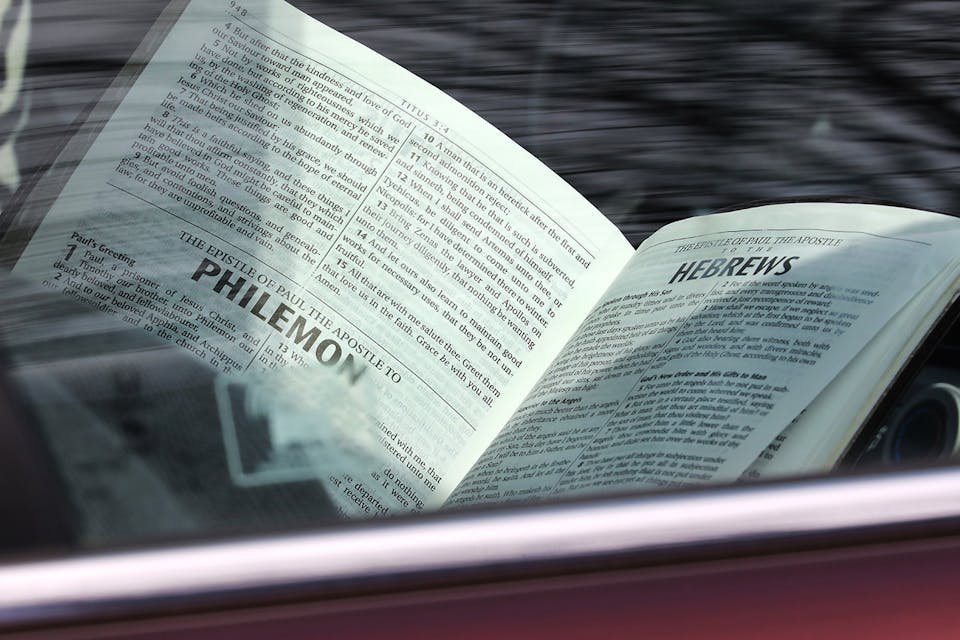 An attendee reads the Bible during a drive-in Easter service in South Easton, MA on April 12, 2020. *Pat Greenhouse/The Boston Globe via Getty Images.* Dreher Main