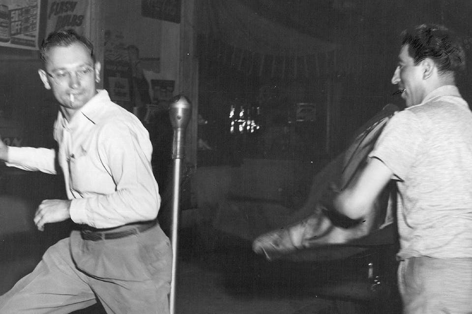 *An unidentified pro-Rosenberg protester takes a swing with his jacket at *Denver Post* photographer Albert Moldvay on June 23, 1953. *Denver Post via Getty Images. Rosenberg Protest Main