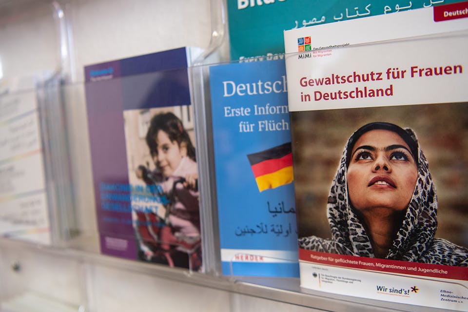 *Information brochures shelf in a shelter for refugee women in Germany.* Monika Skolimowska/picture alliance via Getty Images. Immigrants Germany