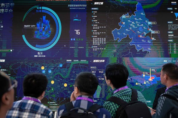 *Visitors look at an AI security software program on a screen at the 14th China International Exhibition on Public Safety and Security in Beijing on October 24, 2018.* NICOLAS ASFOURI / AFP. China AI