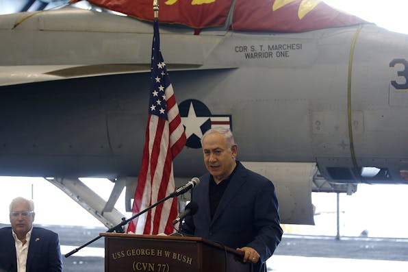*Israeli Prime Minister Benjamin Netanyahu aboard a U.S. aircraft carrier as it docks at the Haifa port on July 3, 2017.* ZVULUN/AFP/Getty Images. Kramer Freilich Main