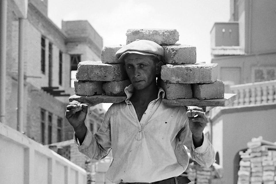 *A man carrying bricks in 1920s Tel Aviv. *Library of Congress. Tel Aviv Bricks Main
