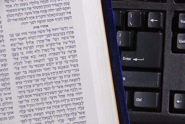 concept of online bible study illustrated with hebrew bible against computer keyboard