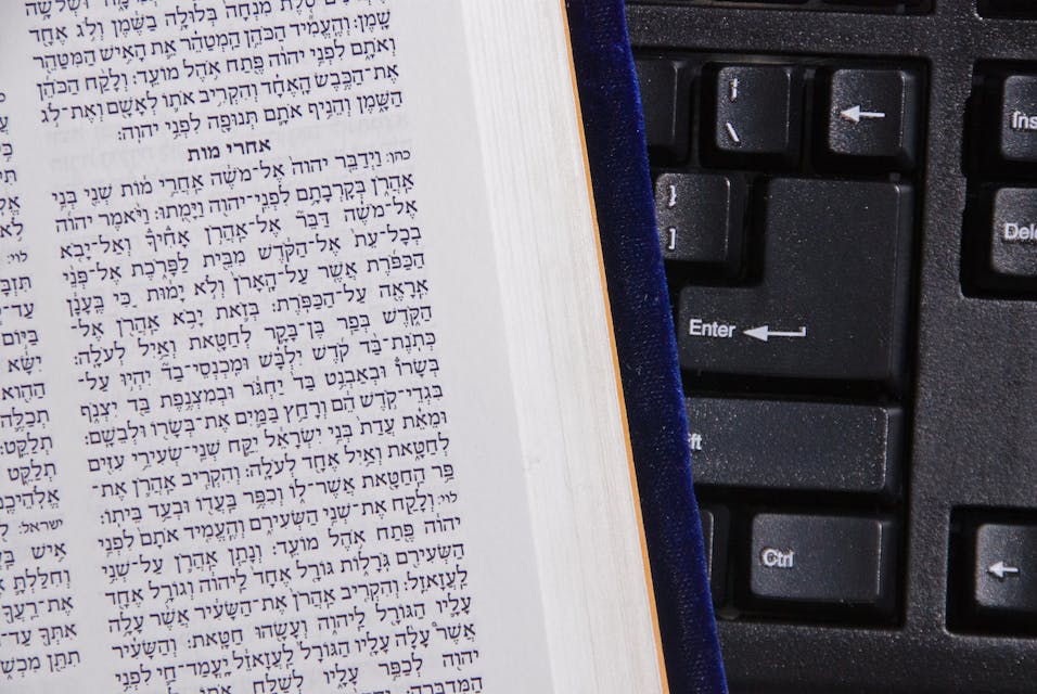 concept of online bible study illustrated with hebrew bible against computer keyboard