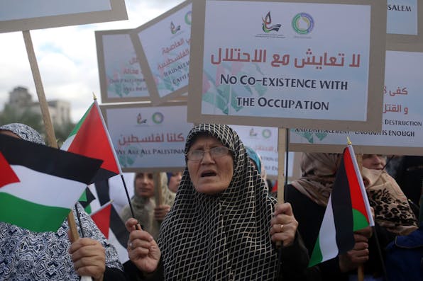 *Palestinian demonstrators hold their national flag and banners during an anti-Israel protest in Gaza City on November 10, 2015.* MOHAMMED ABED/AFP/Getty Images. Gur-Vision-Main