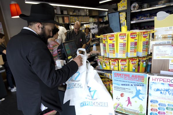 *A man waits in line at a Hypercacher kosher supermarket in Paris on June 26, 2015, six months after the jihadist attack in January.* Kenzo Tribouillard/AFP/Getty Images. Shopping-Jew-Main