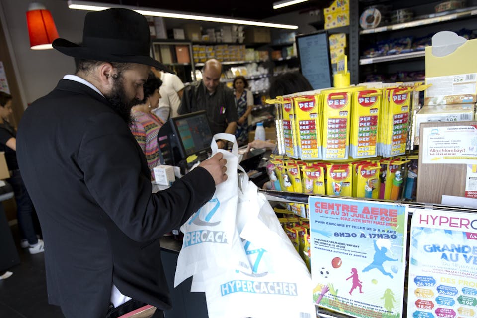 *A man waits in line at a Hypercacher kosher supermarket in Paris on June 26, 2015, six months after the jihadist attack in January.* Kenzo Tribouillard/AFP/Getty Images. Shopping-Jew-Main