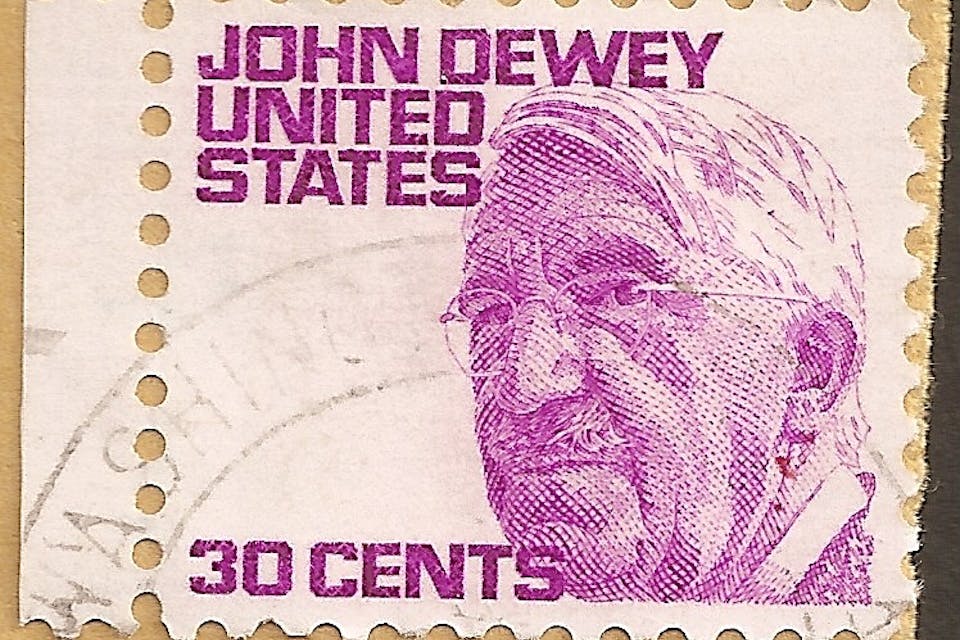 *A 1950s postage stamp featuring the progressive philosopher John Dewey*. Wikimedia. Timbre_USA_John_Dewey_oblW_21101968