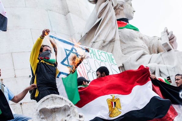 *A protester displays a burning Israeli flag during a demonstration in Paris on July 26, 2014.* AP Photo/Benjamin Girette. Cohen-Main
