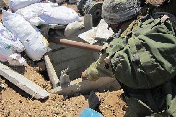 *An IDF soldier peers into a Hamas tunnel in the Gaza Strip in July 2014.* Photo by the IDF Spokesman Unit. idf_soldiers_found_terror_tunnel_in_gaza_14753333031