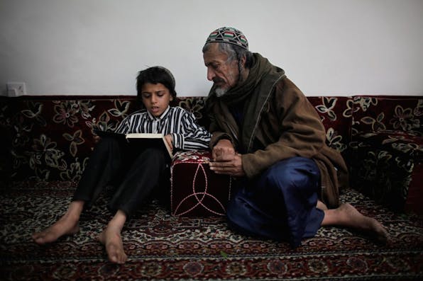 *Nine-year-old Yemeni Jew Salim Moussa reads the Torah with an elder.* Photo by Ed Ou/Getty Images. yemenijewishboystudying