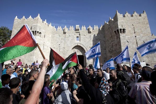 *Israelis and Palestinians wave flags as Israelis march celebrating Jerusalem Day outside Damascus Gate in Jerusalem's old city on Wednesday, May 8, 2013.* Credit: Associated Press/Sebastian Scheiner. ap728416256038