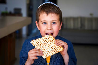 Cute,Caucasian,Child,In,A,Yarmulke,Taking,A,Bite,From
