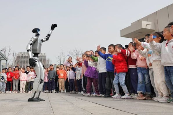 YANTAI, CHINA – MARCH 24, 2025 – A UNITREE G1 humanoid robot waves to children at the Second Experimental Kindergarten in Yantai High-tech Zone, East China’s Shandong province on March 24, 2025. (Photo credit should read CFOTO/Future Publishing via Getty Images)