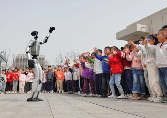 YANTAI, CHINA – MARCH 24, 2025 – A UNITREE G1 humanoid robot waves to children at the Second Experimental Kindergarten in Yantai High-tech Zone, East China’s Shandong province on March 24, 2025. (Photo credit should read CFOTO/Future Publishing via Getty Images)