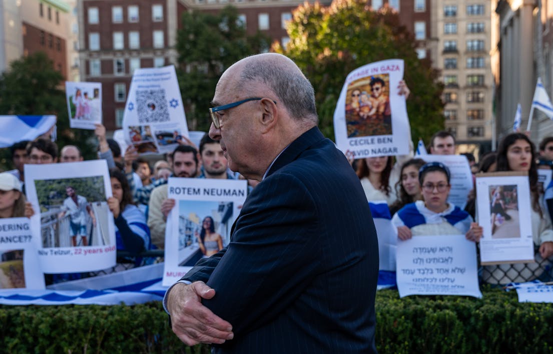 NEW YORK, NEW YORK – OCTOBER 12: A man walks by Columbia students participating in a rally and vigil in support of Israel in response to a neighboring student rally in support of Palestine at the university on October 12, 2023 in New York City. Across the country and around the world, people are holding rallies and vigils for both Palestinians and Israelis following last weekend’s attack by Hamas. On October 7, the Palestinian militant group Hamas launched a surprise attack on Israel from Gaza by land, sea, and air, killing over 1,200 people and wounding thousands. Israeli soldiers and civilians have also been taken hostage by Hamas and moved into Gaza. The attack prompted a declaration of war by Israeli Prime Minister Benjamin Netanyahu, with ongoing airstrikes in Gaza that have killed over a thousand people. (Photo by Spencer Platt/Getty Images)