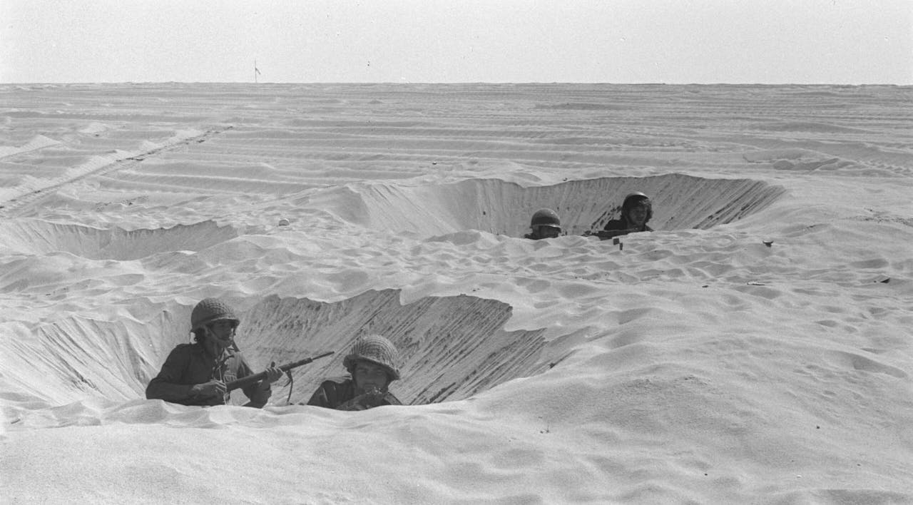 Israeli soldiers in foxholes on October 14, 1973 in the Sinai Desert during the Yom Kippur War. *GPO/Getty Images*. SINAI DESERT, EGYPT – OCTOBER 14: (FILE PHOTO) Israeli soldiers take cover in their foxholes during fighting against the Egyptians October 14, 1973 in the Sinai Desert during the Yom Kippur War. Israeli Prime Minister Ariel Sharon, then an Israeli general, refused to rule out another surprise attack similar to the one launched by the Arab armies when they struck against Israeli troops in the Sinai Desert and Golan Heights on the holiest day of the Jewish calendar on October 6, 1973. (Photo by GPO/Getty Images)