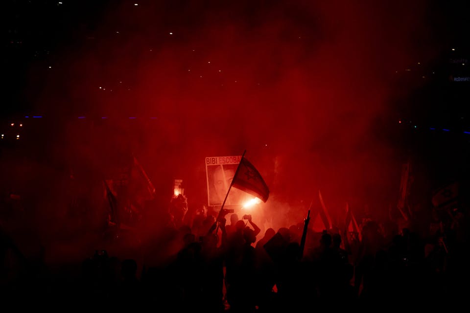 Protesters during a demonstration calling for a hostage deal and against the government of Prime Minister Benjamin Netanyahu on June 15, 2024 in Tel Aviv. *Amir Levy/Getty Images.* TEL AVIV, ISRAEL – JUNE 15: Protesters use smoke torches during a demonstration calling for an hostages deal and against the Israeli Prime Minister Benjamin Netanyahu and his government on June 15, 2024 in Tel Aviv, Israel. Anti-government protests have taken place most Saturdays this year, amid frustration with the Netanyahu government and its failure to secure the release of the remaining hostages captured on Oct. 7.(Photo by Amir Levy/Getty Images)