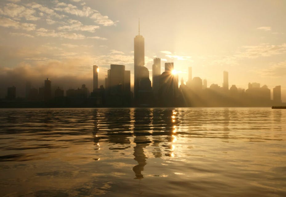 JERSEY CITY, NJ – DECEMBER 25: The sun rises behind the skyline of lower Manhattan and One World Trade Center in New York City on December 25, 2023, as seen from Jersey City, New Jersey.  (Photo by Gary Hershorn/Getty Images)