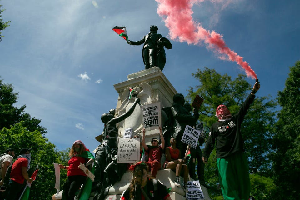 Anti-Israel protesters deface the Rochambeau Statue near the White House on June 8, 2024. *Probal Rashid/LightRocket via Getty Images.* WASHINGTON, DISTRICT OF COLUMBIA, UNITED STATES – 2024/06/08: Pro-Palestinian demonstrators leave Palestinian flags and graffiti on the Rochambeau Statue in Lafayette Park next to the White House during a demonstration. Thousands of pro-Palestinian demonstrators wearing red clothes surround the White House with two miles long red banner symbolizing President Biden’s ‘red line’ of Israeli invasion of Rafah. (Photo by Probal Rashid/LightRocket via Getty Images)