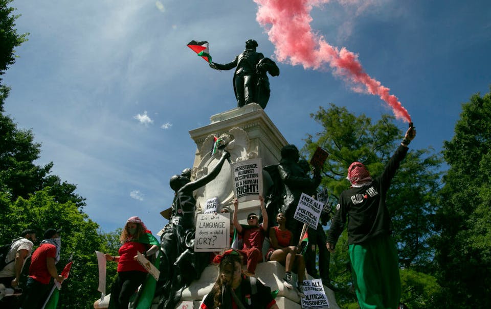 WASHINGTON, DISTRICT OF COLUMBIA, UNITED STATES – 2024/06/08: Pro-Palestinian demonstrators leave Palestinian flags and graffiti on the Rochambeau Statue in Lafayette Park next to the White House during a demonstration. Thousands of pro-Palestinian demonstrators wearing red clothes surround the White House with two miles long red banner symbolizing President Biden’s ‘red line’ of Israeli invasion of Rafah. (Photo by Probal Rashid/LightRocket via Getty Images)