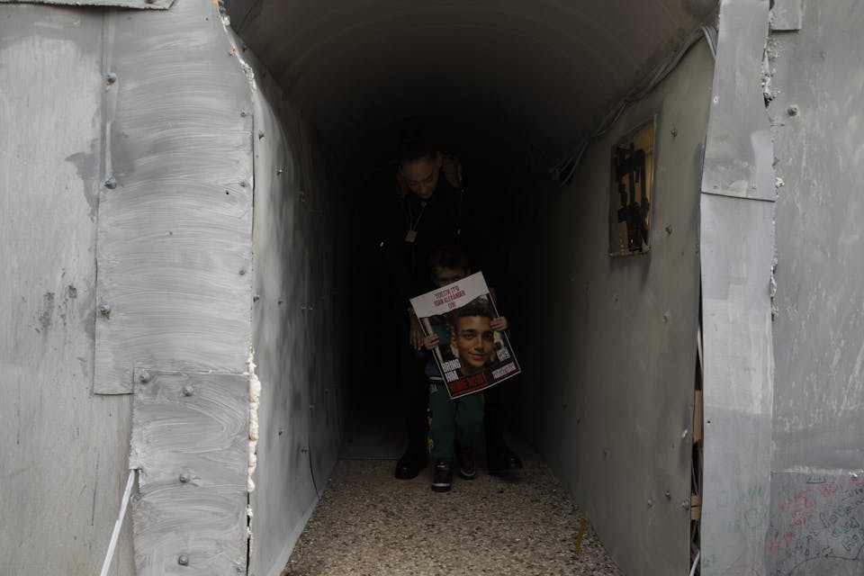 Cousins of a man held hostage in Gaza walk through a tunnel in Tel Aviv meant to simulate a Hamas tunnel tunnel on January 13, 2024. *Amir Levy/Getty Images*. TEL AVIV, ISRAEL – JANUARY 13: Cousins of Edan Alexander, who is held hostage in gaza  walk through a featured tunnel that simulates a Hamas tunnel on January 13, 2024 in Tel Aviv, Israel. The protest featured a 30-meter-long tunnel meant to simulate the conditions in which Israeli hostages are allegedly held in Gaza. More than 100 Israeli hostages captured on Oct. 7 remain held in Gaza by Hamas and other militant groups, according to Israeli authorities.  (Photo by Amir Levy/Getty Images)