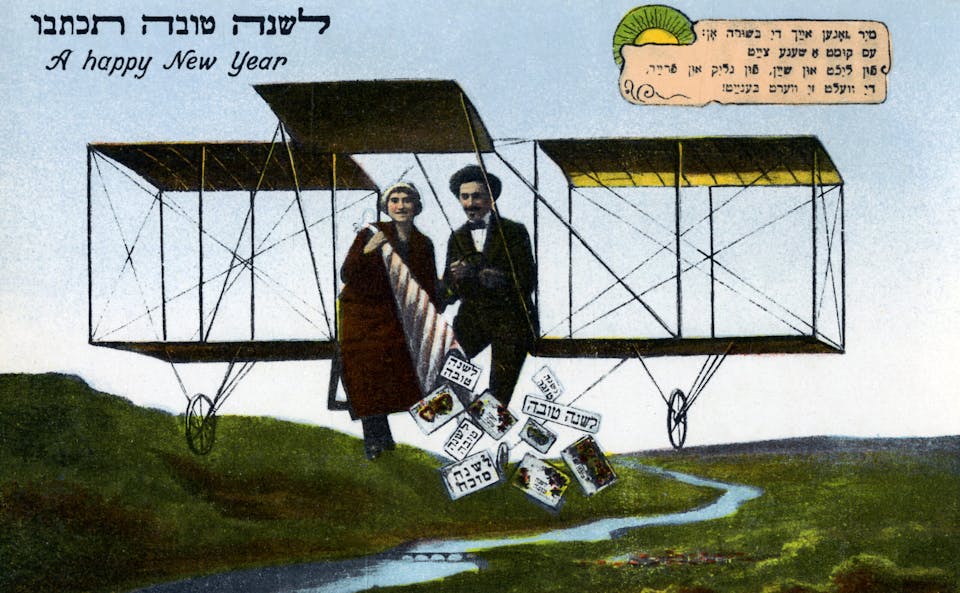 A Jewish postcard featuring a couple flying on an early airplane throwing holiday greetings to the ground below.  Text in Hebrew and English wishing one a Happy Jewish New Year. Artist unknown (Photo by Pierce Archive LLC/Buyenlarge via Getty Images)
