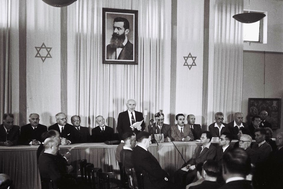 David Ben-Gurion reading the Declaration of Independence on May 14, 1948 during the ceremony founding the state of Israel. *Zoltan Kluger/GPO via Getty Images*. TEL AVIV, ISRAEL – MAY 14: In this handout from the GPO, David Ben Gurion, who was to become Israel’s first Prime Minister, reads the Declaration of Independence May 14, 1948 at the museum in Tel Aviv, during the ceremony founding the State of Israel. (Photo by Zoltan Kluger/GPO via Getty Images)