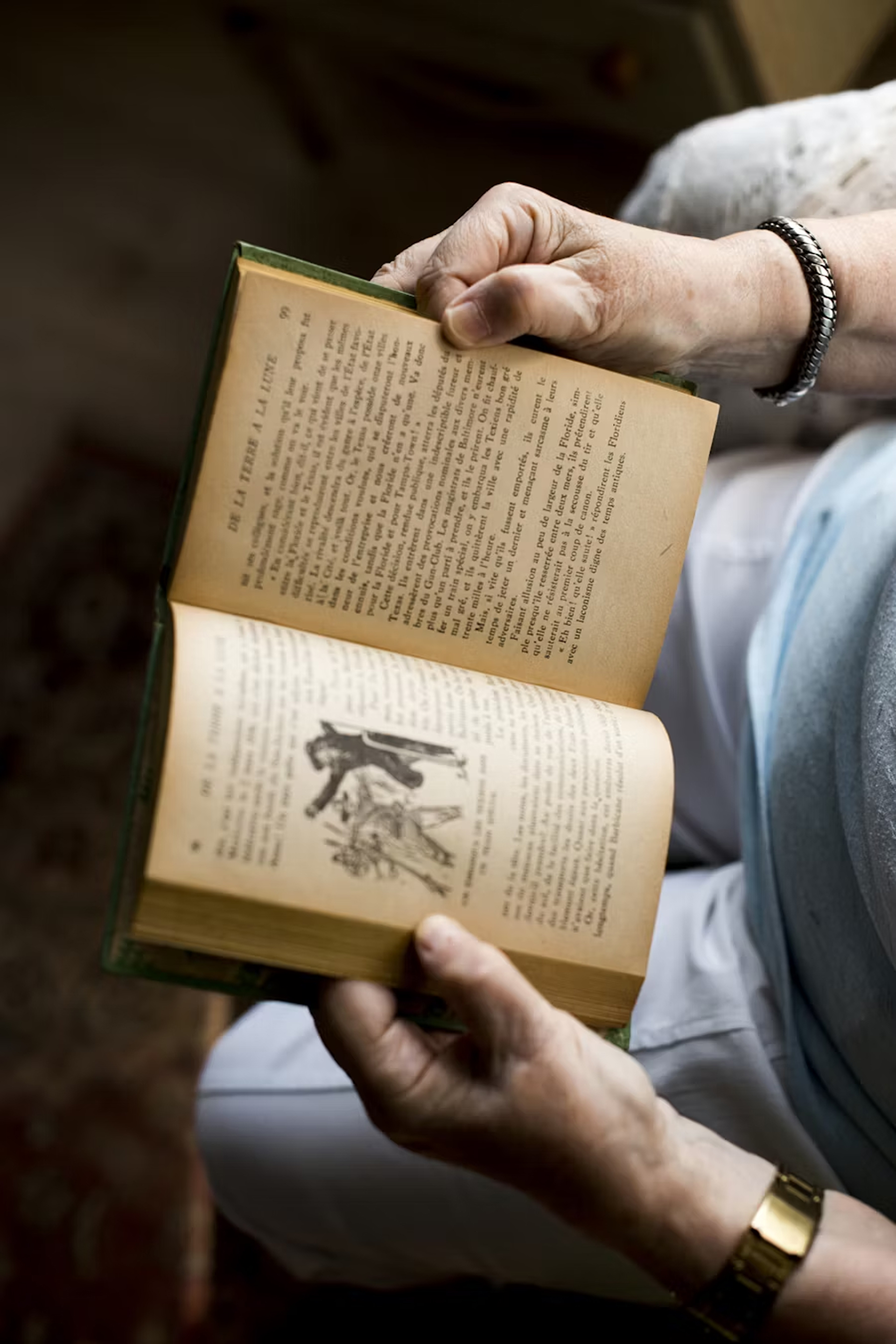 book, publication, person, reading, adult, male, man, passport, wristwatch, bracelet