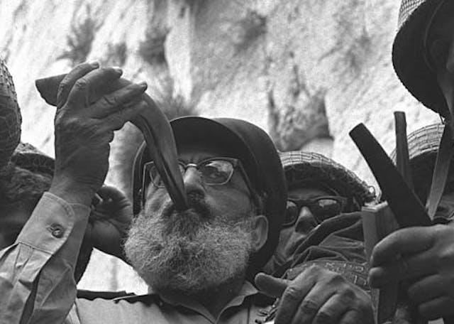 Six_Day_War._Army_chief_chaplain_rabbi_Shlomo_Goren,_who_is_surrounded_by_IDF_soldiers,_blows_the_shofar_in_front_of_the_western_wall_in_Jerusalem._June_1967._D327-043