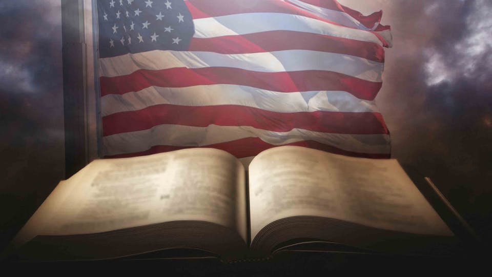 Holy,Bible,With,The,American,Flag,In,The,Background.