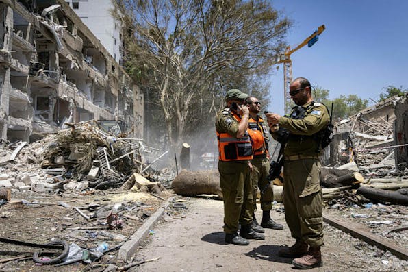 Israeli forces are on the scene where buildings are destroyed as a result of Iran’s missile attack in Tel Aviv, Israel, on June 22, 2025. Israel started invading Iran in the early hours of June 13, and the exchange of fire between the two sides has continued ever since. (Photo by Faiz Abu Rmeleh / Middle East Images via AFP) (Photo by FAIZ ABU RMELEH/Middle East Images/AFP via Getty Images)