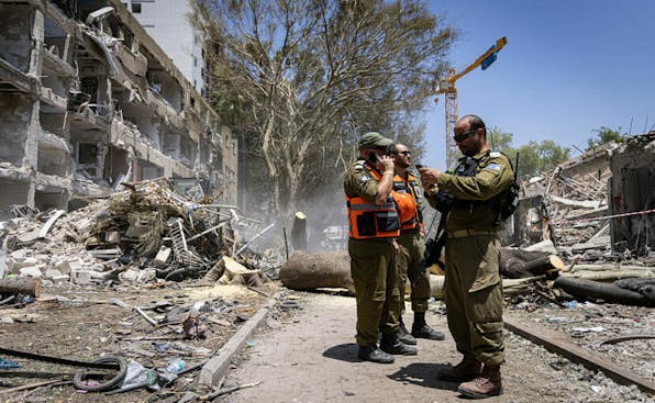 Israeli forces are on the scene where buildings are destroyed as a result of Iran’s missile attack in Tel Aviv, Israel, on June 22, 2025. Israel started invading Iran in the early hours of June 13, and the exchange of fire between the two sides has continued ever since. (Photo by Faiz Abu Rmeleh / Middle East Images via AFP) (Photo by FAIZ ABU RMELEH/Middle East Images/AFP via Getty Images)