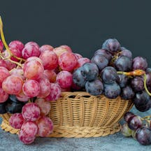 Black,And,Red,Grapes,In,A,Wicker,Basket,On,A