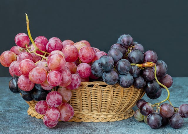 Black,And,Red,Grapes,In,A,Wicker,Basket,On,A