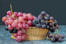 Black,And,Red,Grapes,In,A,Wicker,Basket,On,A