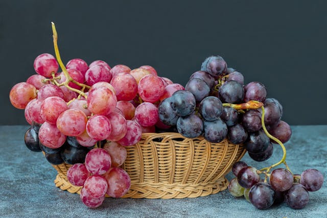 Black,And,Red,Grapes,In,A,Wicker,Basket,On,A