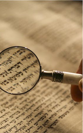 A magnifying glass reading Hebrew text