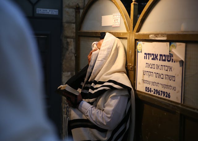 Man Covering Eyes While Praying