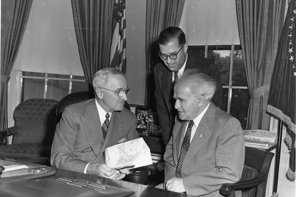 President Harry S. Truman (left) meets with Israeli Prime Minister David Ben-Gurion (right) and Israeli Ambassador Abba Eban (standing) in a gift ceremony in the Oval Office. President Harry S. Truman (left) meets with Israeli Prime Minister David Ben-Gurion (right) and Israeli Ambassador Abba Eban (standing) in a gift ceremony in the Oval Office.